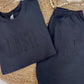 Navy blue sweatshirt and pants with 'DASH' and 'DF' text on a woven mat.
