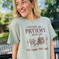 A woman wearing a green short-sleeved graphic tee with the text 'Please be patient with me I'm from the 1900's' printed on it, standing outdoors.