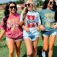 Three women wearing school spirit shirts on a sports field