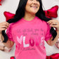 A person wearing a pink t-shirt with the text 'Let all you do be done in LOVE' printed on it, standing in a room with balloons and decorative hearts.
