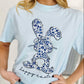 Person wearing a light blue t-shirt with a floral bunny design and 'Happy Easter' text.