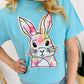 Person wearing a blue t-shirt with a colorful bunny design.