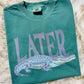 Green t-shirt with purple alligator graphic and 'LATER' gator text on a fur surface Alligator 