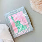 A gray t-shirt with a graphic of the Statue of Liberty in pink and green against a pink background, with the text 'LIBERTY' below the statue.