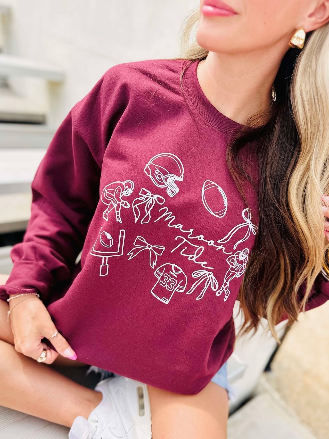 Person wearing a maroon tide sweatshirt with white graphics and text.