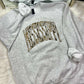 Gray sweatshirt with decorative duck camo text MISSISSIPPI curved arched on a fluffy surface