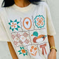 Person wearing a white t-shirt with colorful Antique Designs patterns and a mallard duck illustration.