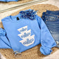 Blue sweatshirt with white floral designs on a woven mat