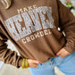 Person wearing a brown sweatshirt with text and leopard print design, standing on a sidewalk.