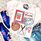 White t-shirt with sports-themed design, blue sneakers, baseball glove, and denim shorts on a speckled surface.