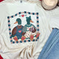 White t-shirt with duck design on a red surface with jeans and candles.
