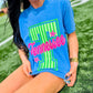 Person wearing a blue t-shirt with 'Tennessee' design on grass