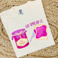 A youth-sized white t-shirt with a graphic print of a jar and a slice of bread, alongside the phrase 'GO SPREAD IT.'
