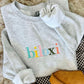 Ash sweatshirt with "Biloxi" on it in Muti color rainbow thread