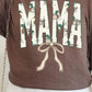 A person wearing a brown DTF tee with the word 'MAMA' and a graphic of ducks and a bow on it.