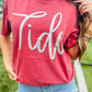Person wearing a red 'Tide' t-shirt outdoors