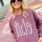 Woman wearing a purple sweatshirt with 'tide' text, standing outdoors.