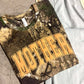 Realtree Camouflage t-shirt with 'MOTHER' text on a concrete surface