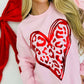 Person wearing a pink sweatshirt with a red leo metallic heart design on a white background