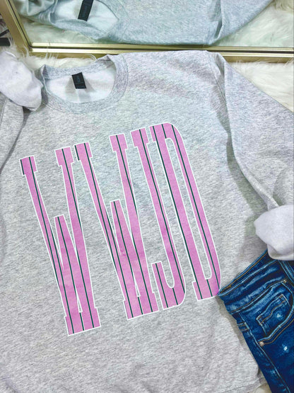 Gray sweatshirt with pink and green stripe WWJD text design on a white surface
