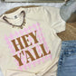 Beige t-shirt with 'HEY YALL' puff text on a dtf gingham stripes casual setting with jeans and accessories.
