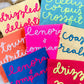 Colorful tote bags with text on a white surface