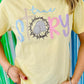 Person wearing a yellow t-shirt with 'true story' text with crown of thorns and tomb against a colorful striped background