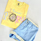 Yellow t-shirt with 'true story' text and blue shorts on a light gray background
