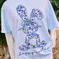 Light blue t-shirt with a blue floral chino bunny design and 'Happy Easter' text, worn outdoors.