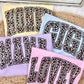 Set of towels with leopard print text on a textured surface