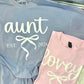 Two shirts, one blue and one pink, with 'aunt est. 2026' and 'lovey est. 2026' text.