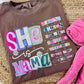 Brown t-shirt with colorful text design on a woven surface