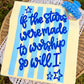Wooden sign with blue text and stars on a yellow background, placed on a woven surface.