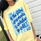 Person wearing a yellow t-shirt with blue text design "If the stars were made to worship so will I"