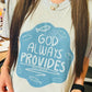 Person wearing a t-shirt with 'God Always Provides' text and fish illustrations.
