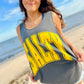 Woman wearing a gray tank top with 'Salty' printed in yellow on a beach.