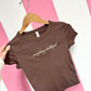 Brown t-shirt with 'everything hallelujah' text on a pink and white striped background