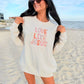 Woman wearing a 'Love Like Jesus' embroidery shirt on a beach