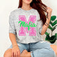 Woman wearing a gray oversized shirt with 'Mafia' print, sitting on a white background.