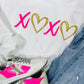 A white sweatshirt with 'XOXO' and heart vinyl designs, paired with blue denim jeans and white sneakers with pink accents.