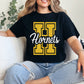 Person wearing a black t-shirt with 'Hornets' design, sitting on a couch.