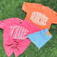 Two t-shirts with 'TIDE' and 'TENNESSEE' text on grass