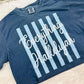 Blue t-shirt with 'Everything Hallelujah' text on a white surface