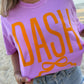 Person wearing a purple t-shirt with 'DASH' printed in orange on a beach.
