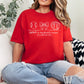 Person wearing a red t-shirt with sports-themed design and "Person wearing a dark gray t-shirt with a "Softball is my favorite season" graphic design and text, sitting on a couch" text, sitting on a couch.